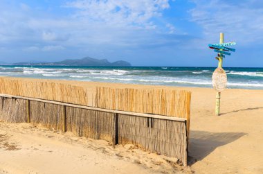 Çit kumlu plaj deniz dalgaları beyaz bulutlar mavi gökyüzü kutup işareti, Can Picafort, Mayorka Adası, İspanya