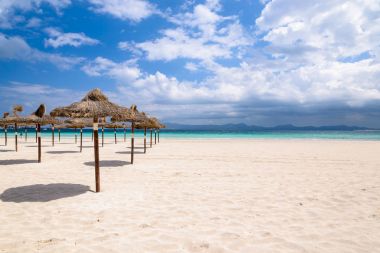 Satır satır güneş gölge şemsiye plaj beyaz kum deniz beyaz bulutlar mavi gökyüzü, Alcudia, Mayorka Adası, İspanya