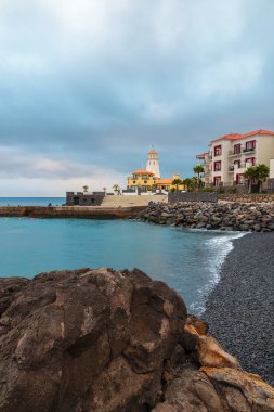 Siyah taş volkanik deniz feneri görünümü bulutlu gökyüzü Doğu c plaj.