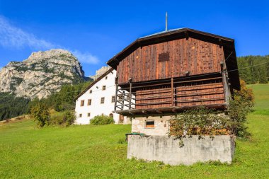 Üzerinde arka planda Dolomites Dağları ile yeşil çayır çiftlik evleri Corvara, Trentino Alto Adige, İtalya