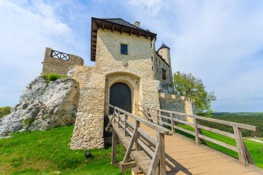 Ahşap köprü girişinde güzel Bobolice Ortaçağ Kalesi güneşli, Polonya