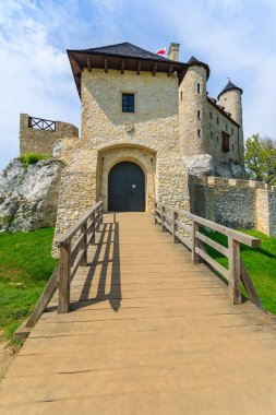 Ahşap köprü girişinde güzel Bobolice Ortaçağ Kalesi güneşli, Polonya