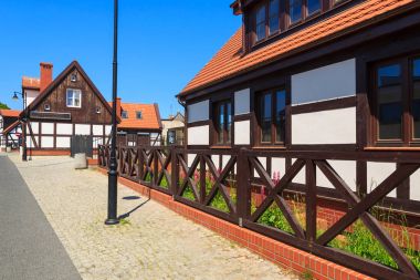 Traditional houses on street on sunny day in Ustka seaside town on Baltic Sea, Poland clipart