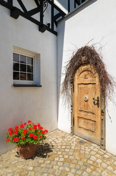 Door to typical house decorated with flowers in Ustka seaside town on Baltic Sea, Poland