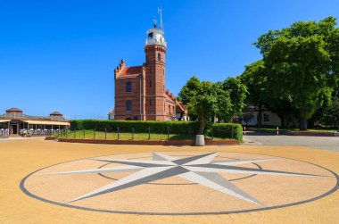 Brick lighthouse building compass rose square park, Ustka town, Baltic Sea, Poland clipart