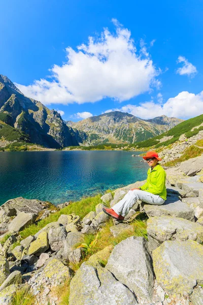 Woman tourist at Czarny Staw lake in summer, Tatra Mountains