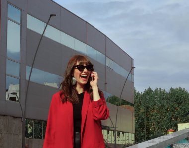 Güzel genç bir kadın cep telefonuyla konuşuyor.