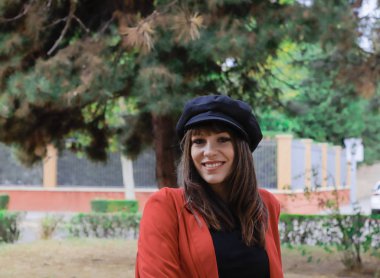 Kırmızı ceketli, siyah şapkalı güzel bir kadın.