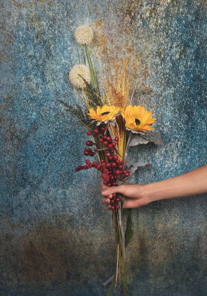 Menselijke Hand Met Een Decoratief Boeket Bloemen Geïsoleerd Een Blauwe — Stockfoto