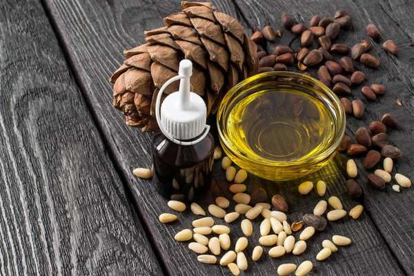 Frutos secos (semillas), cono y aceite de pino siberiano — Foto de Stock