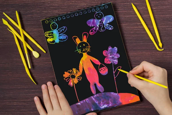 Child makes image Easter bunny in scratchboard technique — Stock Photo, Image