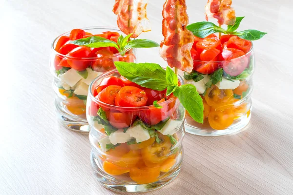 Праздничный салат капрезе с жареным беконом на шашлыках в стаканах — стоковое фото