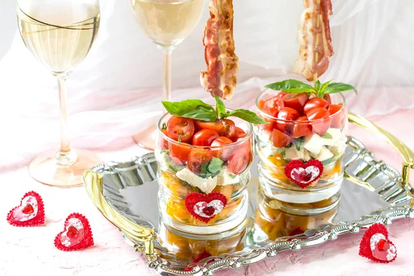 Festive caprese salad with fried bacon on skewers in glasses — Stock Photo, Image