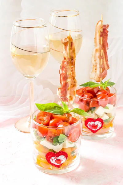 Festive caprese salad with fried bacon on skewers in glasses — Stock Photo, Image