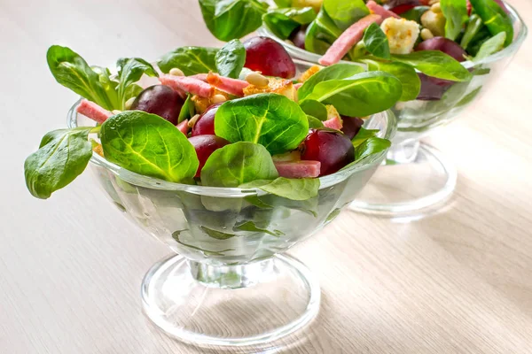 Салат со свежим кукурузным салатом, виноградом, колбасой и гренками — стоковое фото