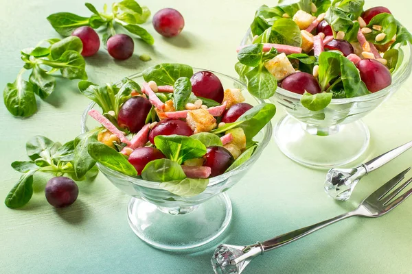 Salad with fresh corn salad, grapes, sausage and croutons