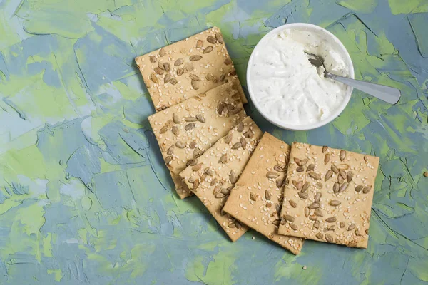 Hausgemachte Cracker mit Sesam, Sonnenblumenkernen und Frischkäse — Stockfoto