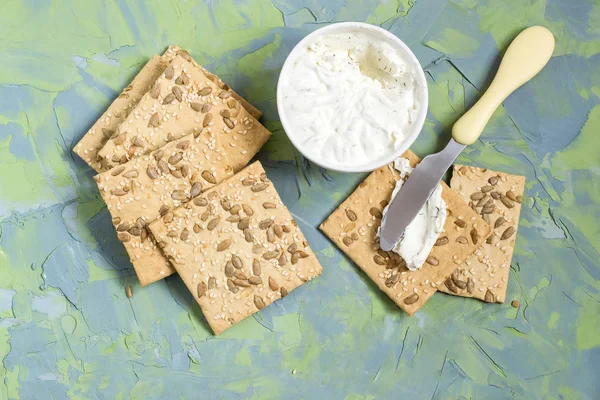 Hausgemachte Cracker mit Sesam, Sonnenblumenkernen und Frischkäse — Stockfoto