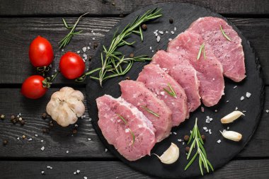 Ham kemiksiz domuz pirzolası, sebzeler, otlar ve baharatlar 