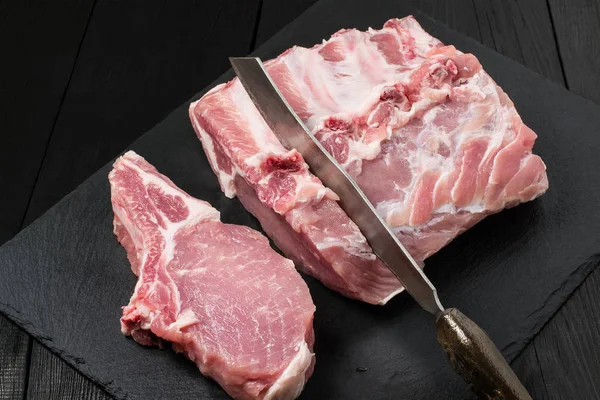 Filet de porc cru, couteau et fourchette sur plaque d'ardoise — Photo
