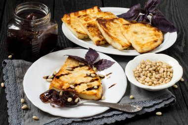 Kızarmış peynir, soğan reçeli ve Sibirya çam fıstığı ile servis edilir 