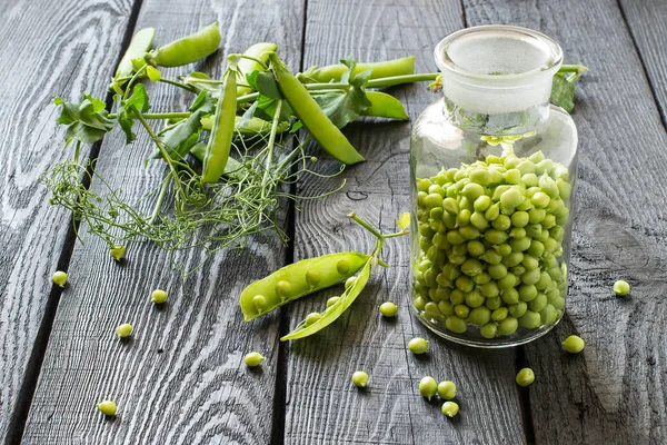 Pois verts en pot et branches en gousses — Photo