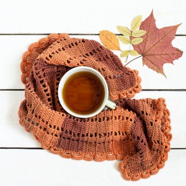 Fincan çay, örme eşarp ve kuru sonbahar yaprakları 