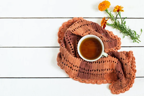 Kopp te, stickad halsduk och blommor tagetes — Stockfoto