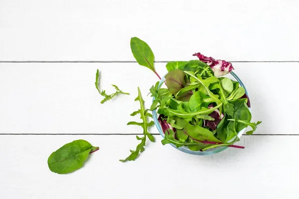 Различные листья салата в стеклянной чаше — стоковое фото