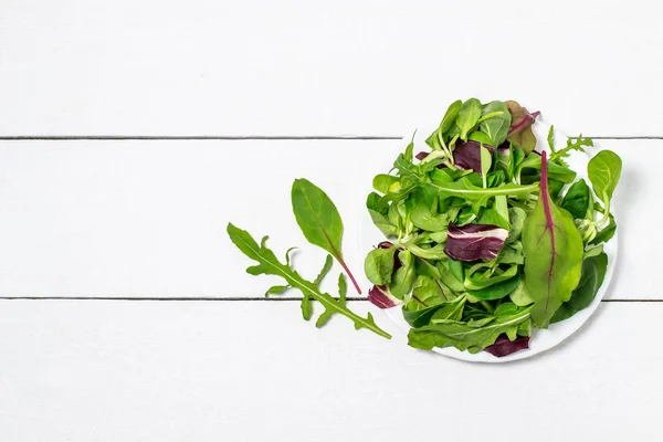 Différentes feuilles de salade sur assiette — Photo