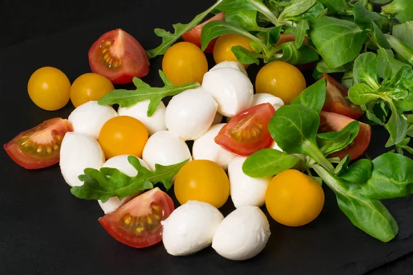 Моцарелла, помидоры и различные листья салата — стоковое фото