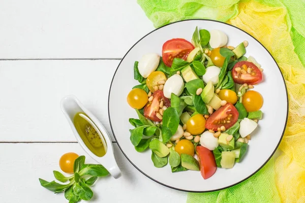 Свежий салат с моцареллой, помидорами, авокадо и салатом — стоковое фото