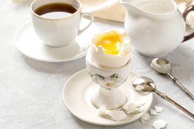 Breakfast. Soft-boiled egg, coffee and cream  clipart