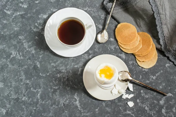Breakfast. Soft-boiled eggs, cup of coffee and crispy corn chips