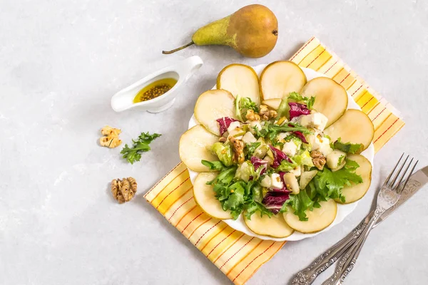 Салат с грушей, сыром фета, салатом и грецкими орехами — стоковое фото
