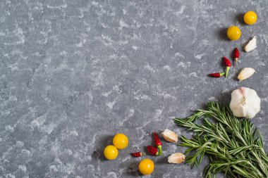 Rosemary, domates, sarımsak ve acı biber gri arka plan üzerinde 