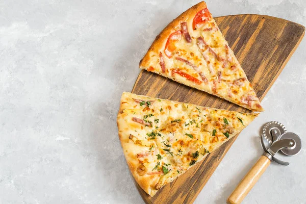 Две разные части пиццы на деревянной доске — стоковое фото