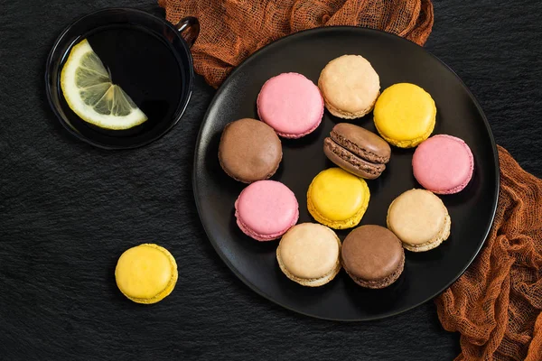 Different macaroon on black plate — Stock Photo, Image