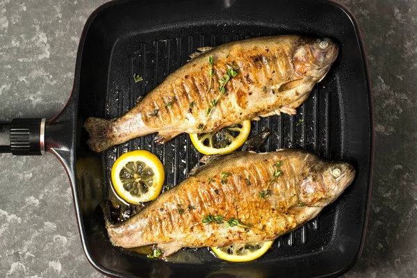 Two trout grilled in frying pan