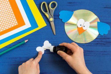 Child makes bird from CD. Step 10  clipart