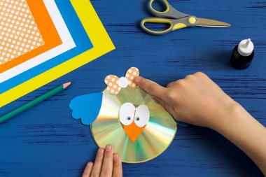Child makes bird from CD. Step 11  clipart
