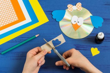 Child makes bird from CD. Step 13  clipart