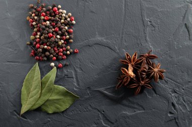 Koyu bir arka planda defne yaprağı, biber ve yıldız anason