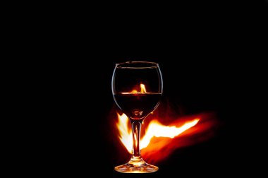 Yanan şaraplı cam ve siyah arka plan yalıtımında alev.