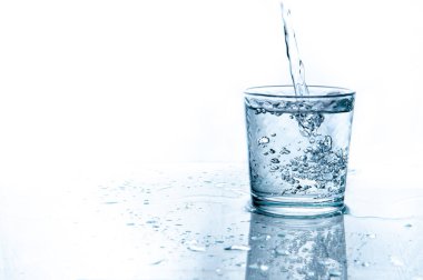 Beyaz arka planda izole edilmiş camdan su sıçrıyor.