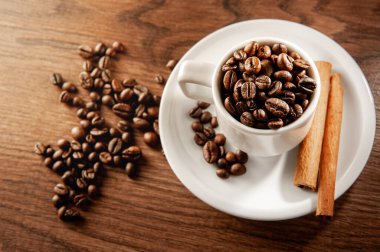 Kahve fincanındaki kahve çekirdekleri ve tarçın çubukları. Üst görünüm