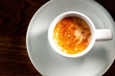 Beyaz çay tabağında bir fincan espresso, yakın çekim ve üst manzara.