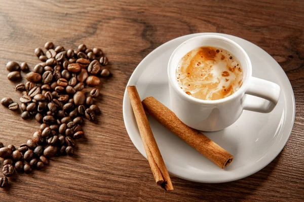 Café matutino. Taza de café, canela y granos de café sobre fondo de madera. Vista superior . — Foto de Stock
