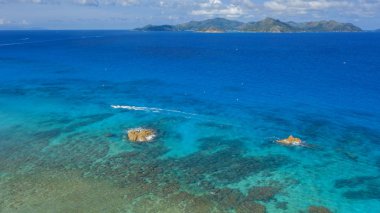 Gezegenin tropik bölgeleri. Seyshell 'ler. İHA 'dan ateş ediliyor. Okyanusun saf turkuaz suları. Beyaz mercan kumu ve mavi gölcükler.