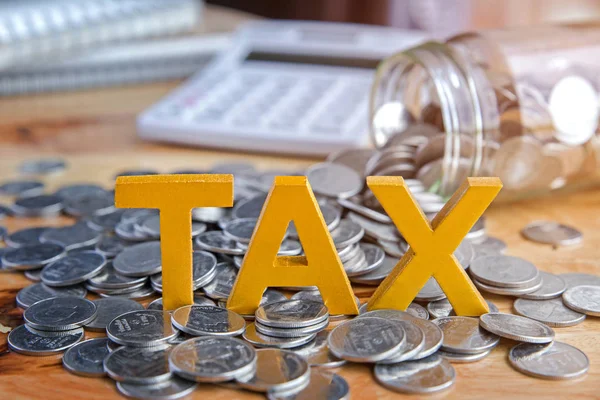 Tax Concept.Word tax with stacked coins there is a notebook calc — Stock Photo, Image
